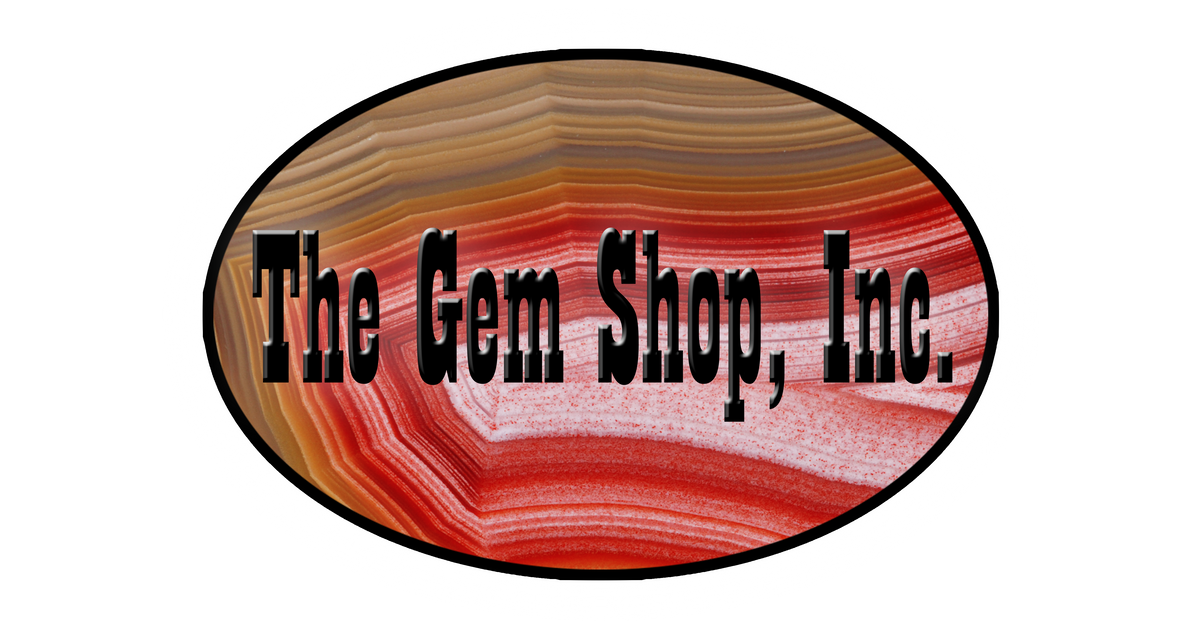 The Gem Shop, Inc. logo with a glowing gemstone mark, on a white panel, from the official The Gem Shop website.