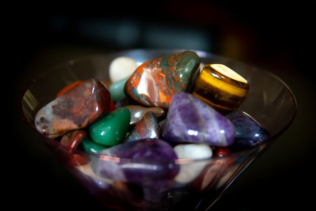 Close-up of polished cabochons and cut stone pieces in warm tones, the featured image on the official Wisconsin Union Intro to Lapidary event page.